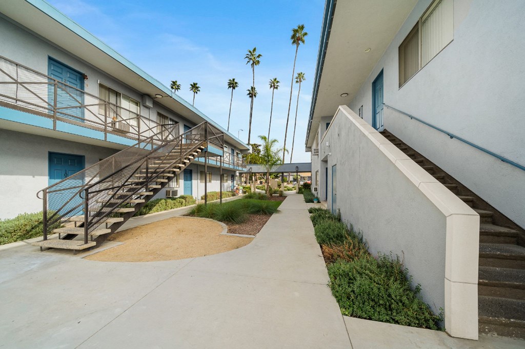 the sidewalk between two apartment buildings with stairs