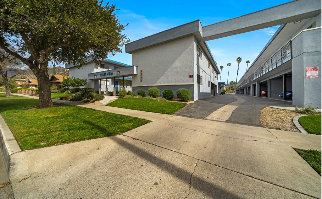 a view of the exterior of a building with sidewalks and grass