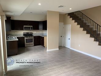 an empty kitchen and staircase in a new home