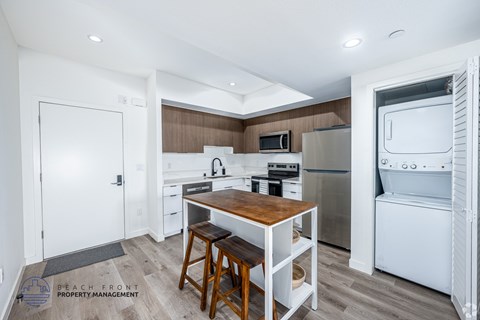 A kitchen with a wooden table and bar stools.