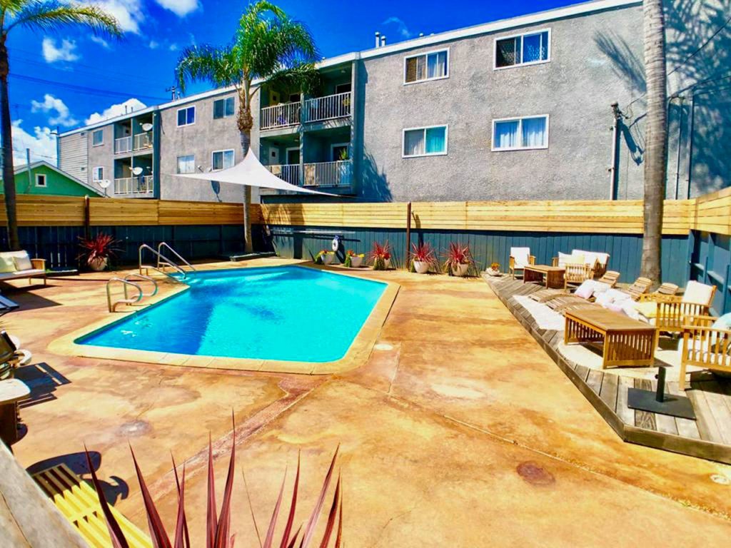 A pool surrounded by a wooden fence and chairs.