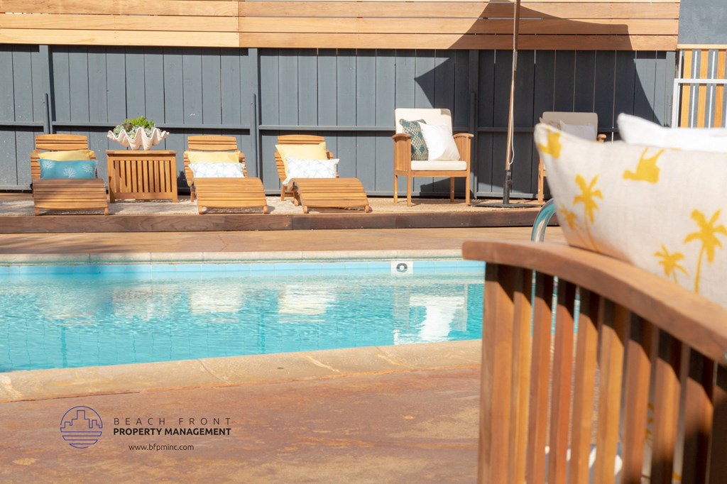 A pool with chairs and umbrellas around it.