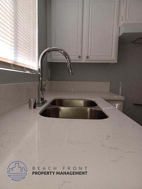 a white counter top with a sink in a kitchen