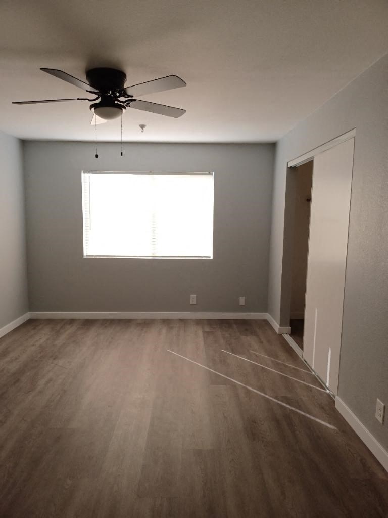 an empty room with a ceiling fan and a window