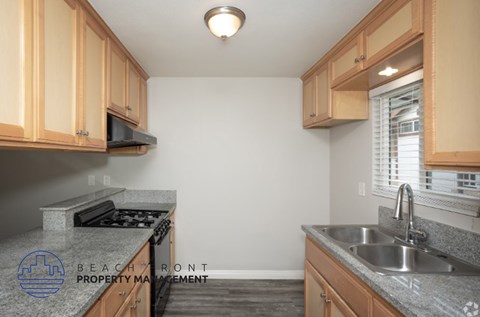 A kitchen with granite countertops and wooden cabinets.