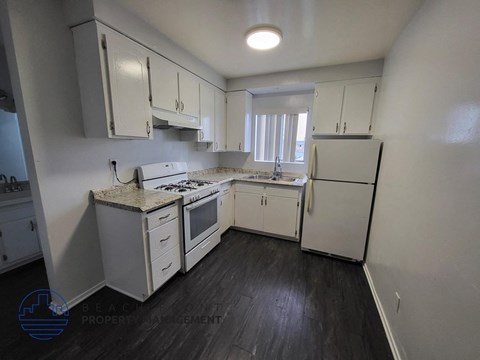 A kitchen with white appliances and cabinets.