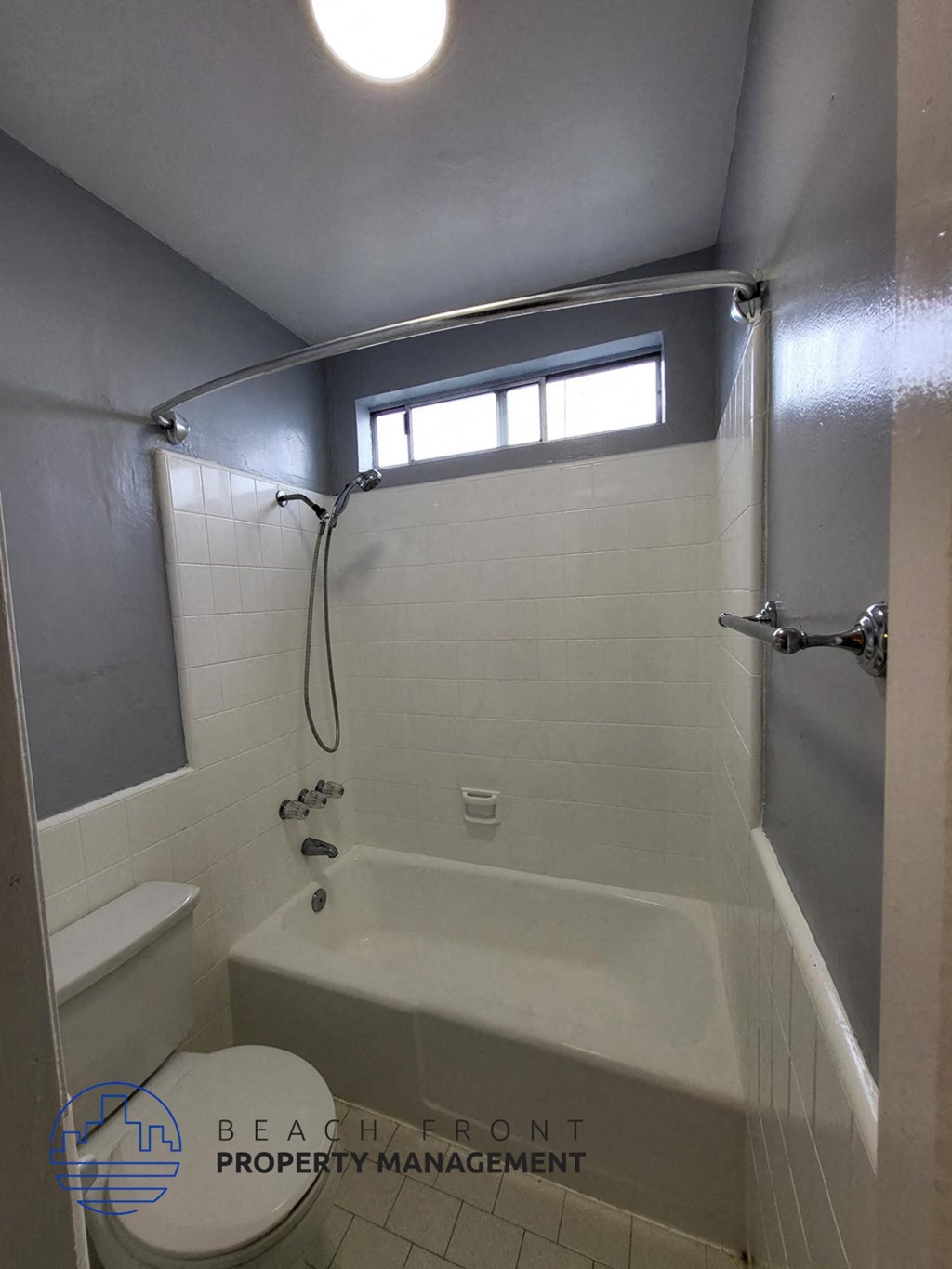 a bathroom with a shower and a toilet and a window
