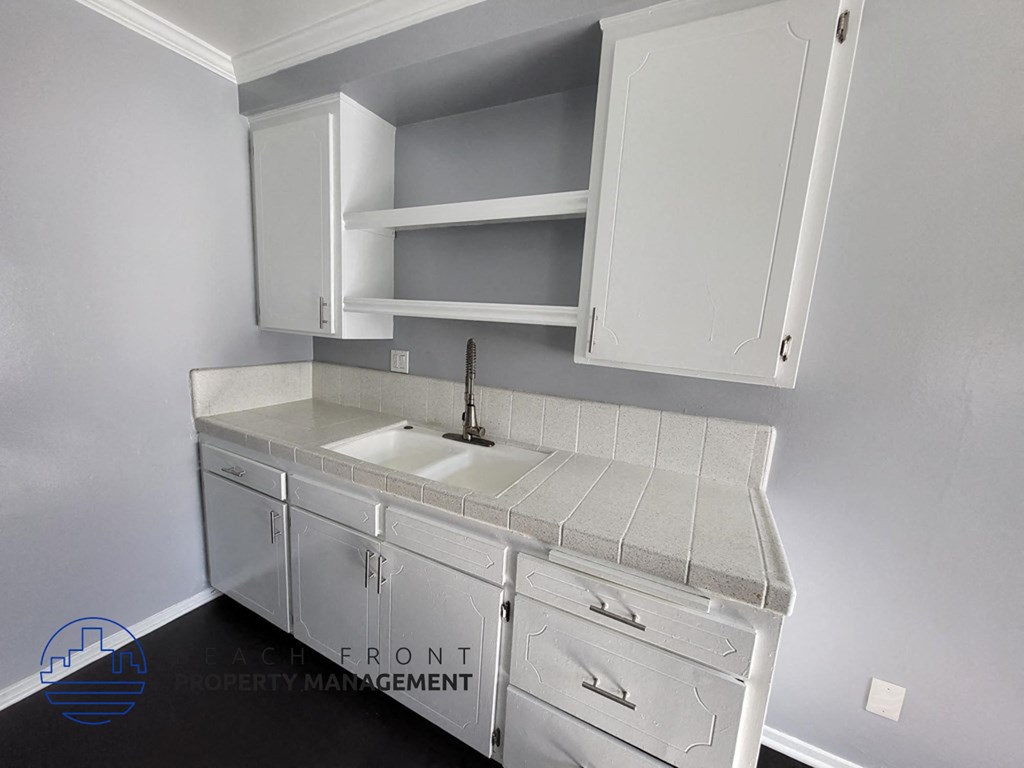 a small kitchen with white cabinets and a sink