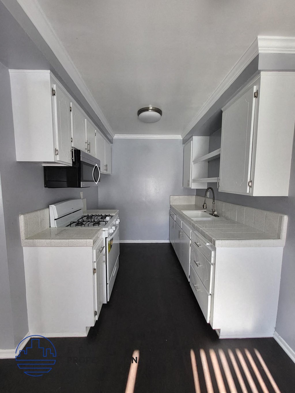 a kitchen with white cabinets and a stove and a sink