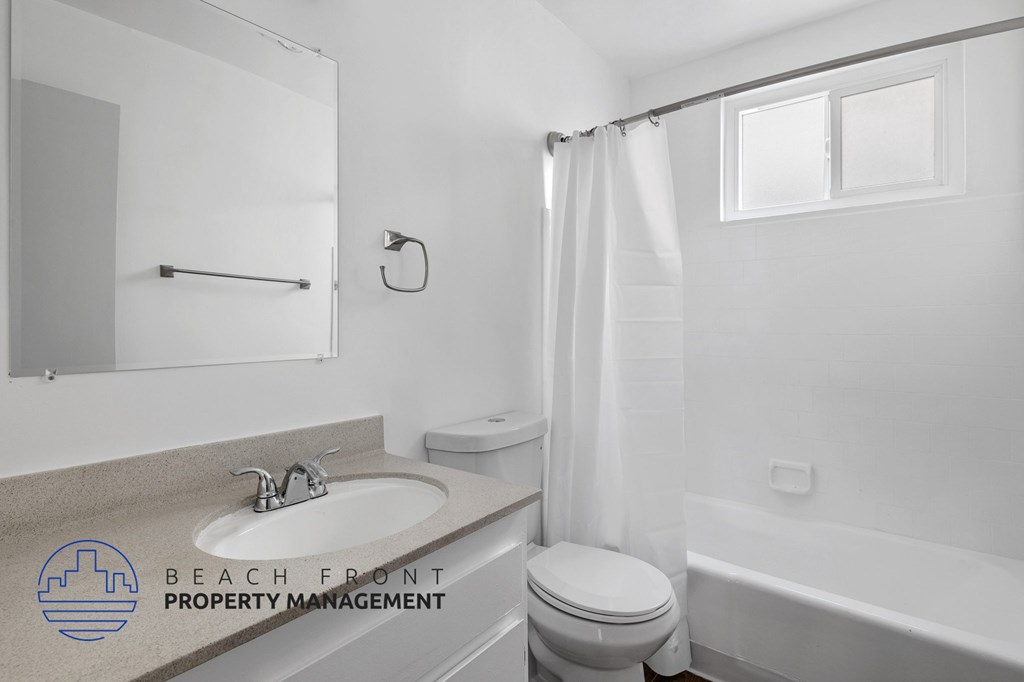 A white bathroom with a sink, toilet, and bathtub.