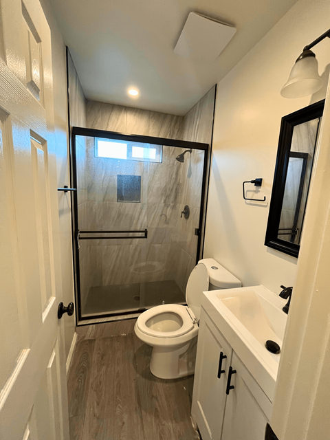 a small bathroom with a shower toilet and sink