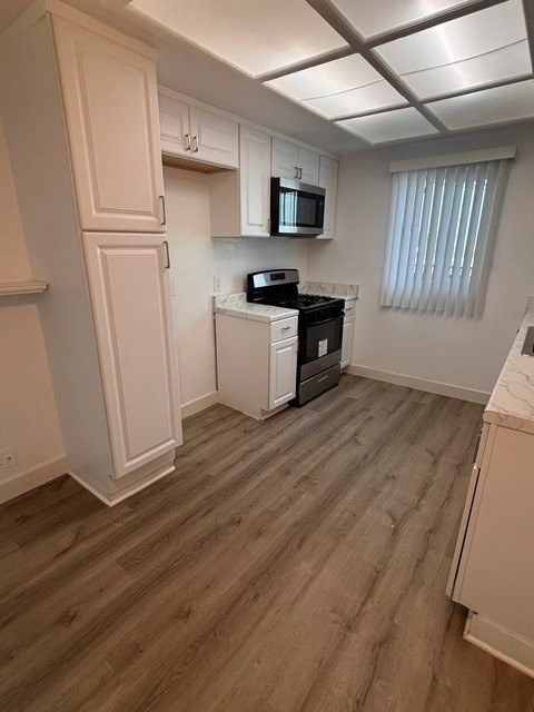 A kitchen with white cabinets and a black stove top oven.