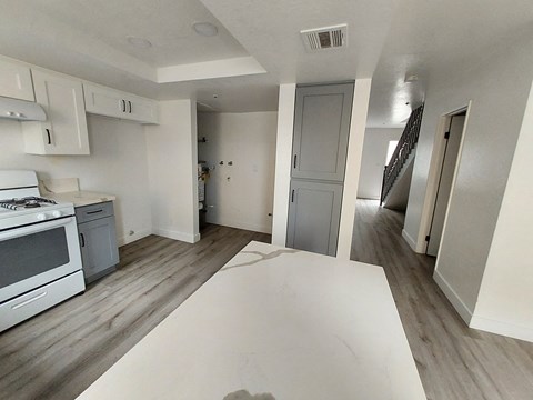 a renovated kitchen with white countertops and a white table in the middle of a