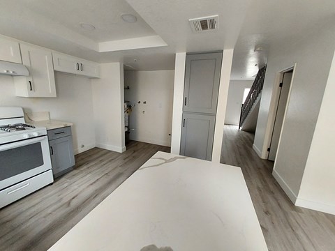 A kitchen with a white stove top oven and a white counter top.