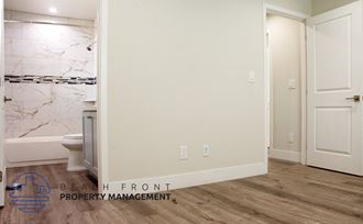 a bathroom with a toilet and a shower and a white door