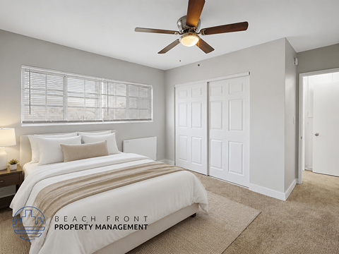 A bedroom with a bed, a ceiling fan, and a window with blinds.