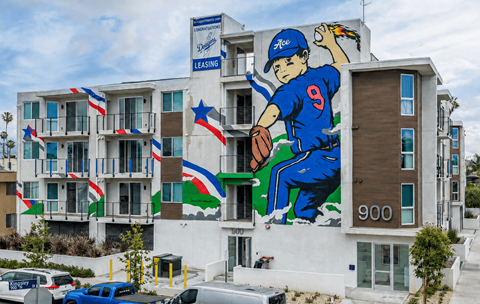 A large mural of a baseball player in blue jersey number 9 is painted on the side of a building.