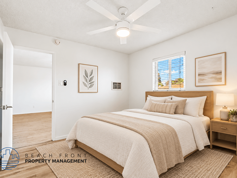 A bedroom with a large bed and a ceiling fan.