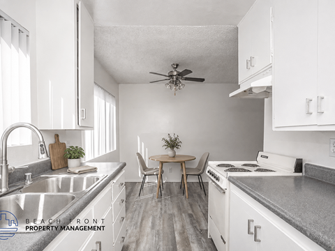 A kitchen with white cabinets and a wooden table.