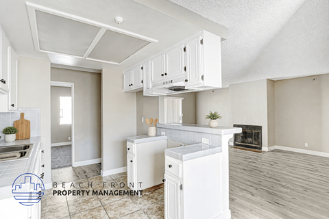 A kitchen with white cabinets and a wooden floor.