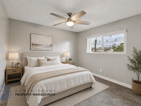 A bedroom with a large bed and a ceiling fan.