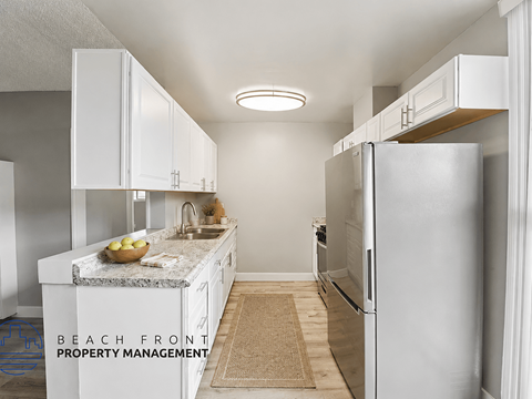 A kitchen with white cabinets and a granite countertop.
