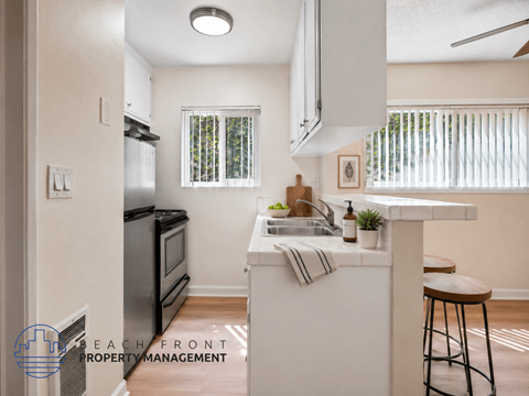 A kitchen with a refrigerator, microwave, and sink.