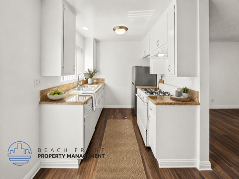 A kitchen with white cabinets and a brown rug on the floor.