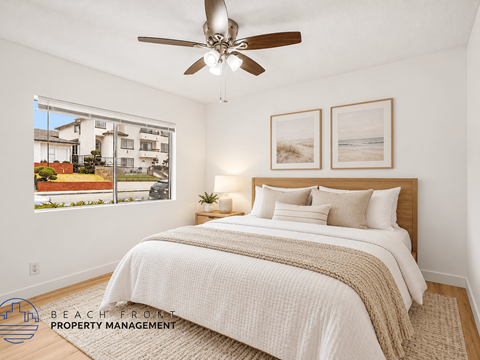 A bedroom with a large bed and a ceiling fan.