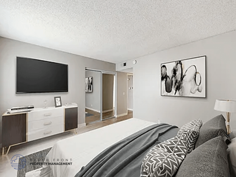 A modern bedroom with a large bed and a television.