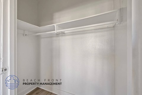 A white empty pantry with a logo of Beach Front Property Management.