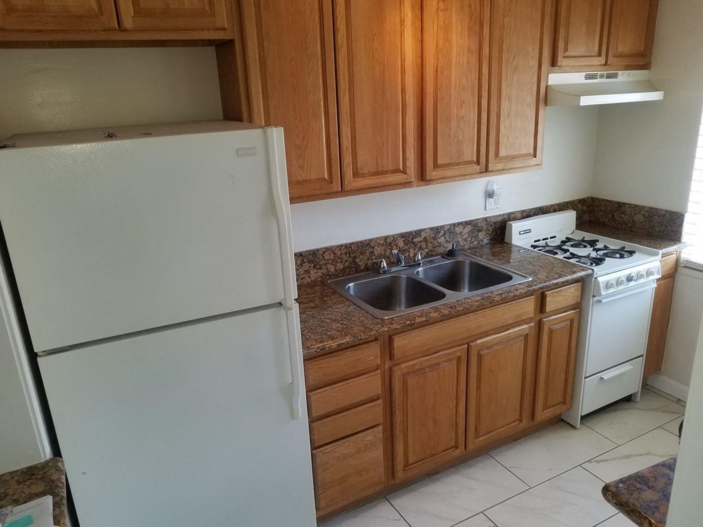 a kitchen with white appliances and wooden cabinets