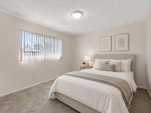 A bedroom with a large bed and two picture frames on the wall.