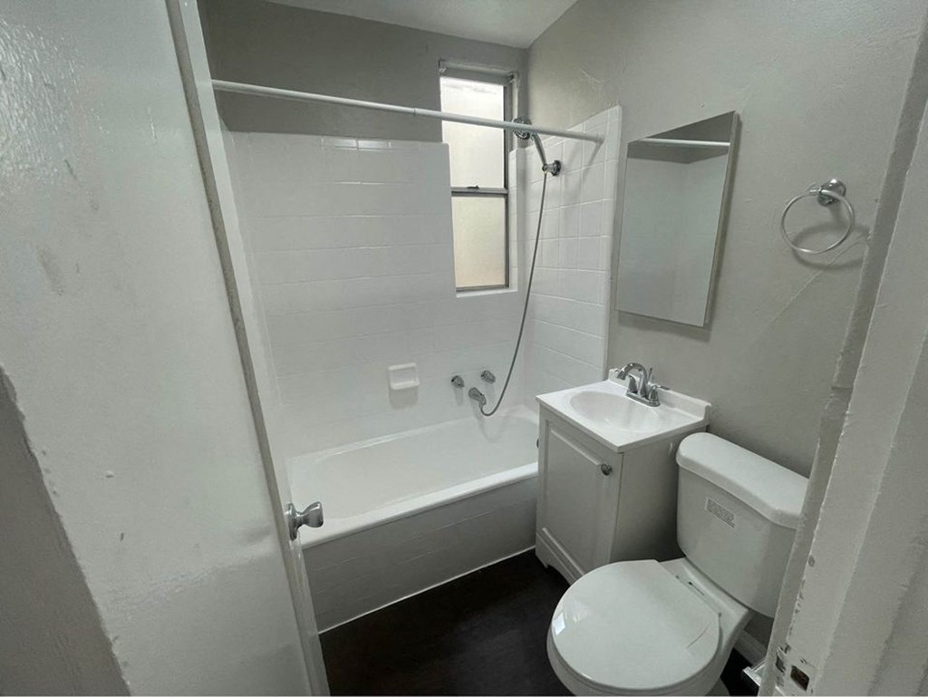 a bathroom with a toilet and a tub and a sink