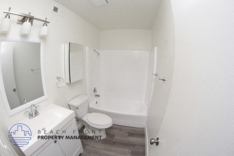 a white bathroom with a white toilet and a white shower