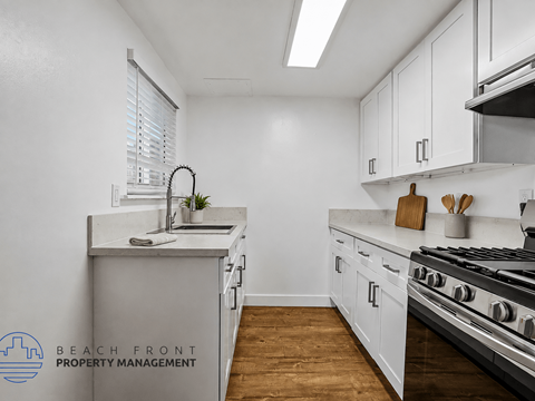 A kitchen with white cabinets and a stainless steel stove.