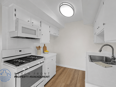 A kitchen with white cabinets and a black stove top oven.
