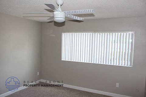 a living room with a ceiling fan and a window