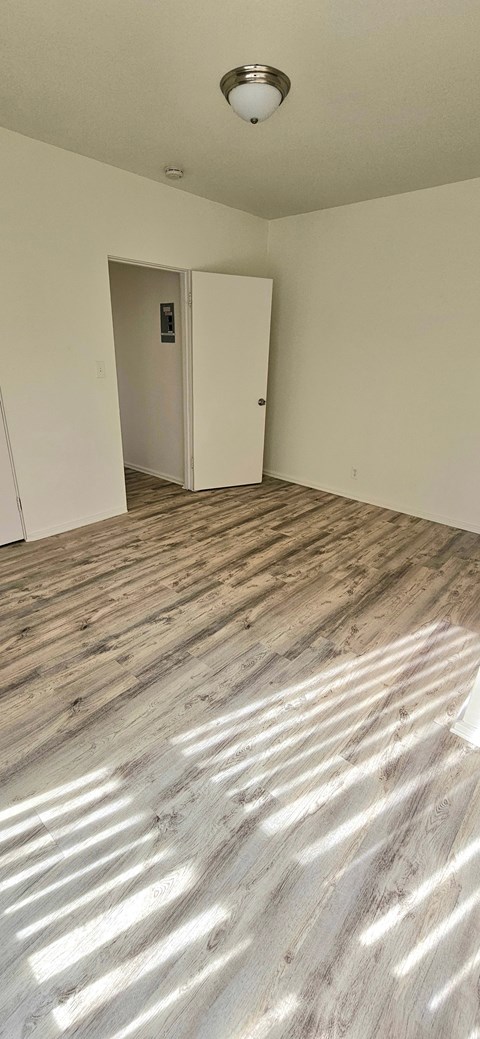 A room with a wooden floor and a white ceiling with a light fixture.