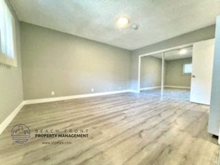 an empty living room with wood flooring in an empty house