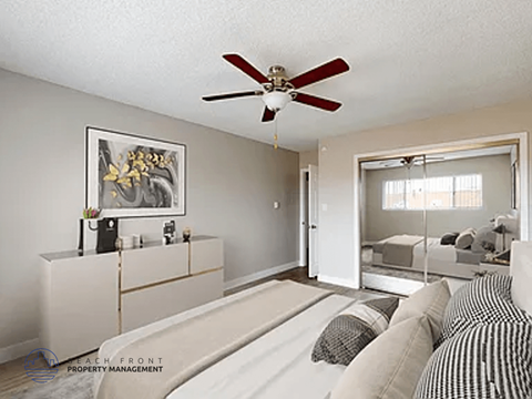 A living room with a ceiling fan and a painting on the wall.