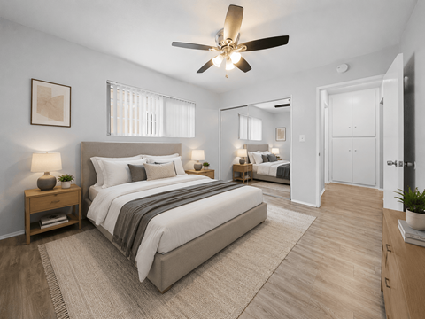 A bedroom with a large bed and a ceiling fan.