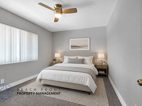 A well-lit bedroom with a large bed and a ceiling fan.