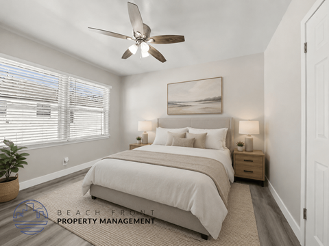 A well-lit bedroom with a large bed and a ceiling fan.