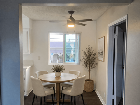 A dining room with a round table and chairs.