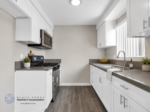 A kitchen with white cabinets and a black stove top.