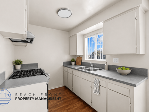 A kitchen with white cabinets and a stove top oven.