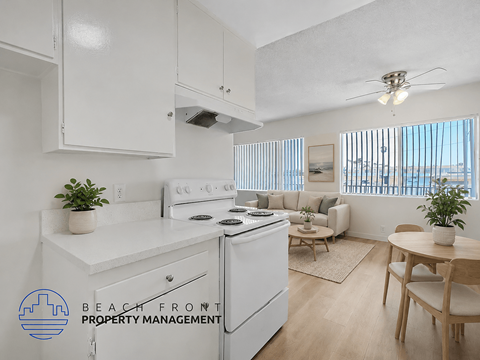 A kitchen with white appliances and a dining table with chairs.
