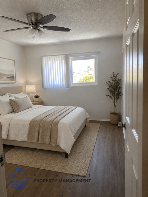 A bedroom with a bed, a ceiling fan, and a window with blinds.