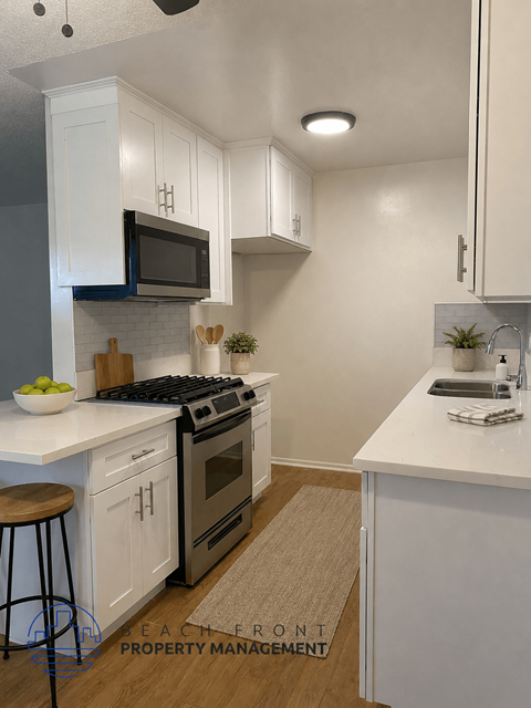 A modern kitchen with white cabinets and a black stove top oven.